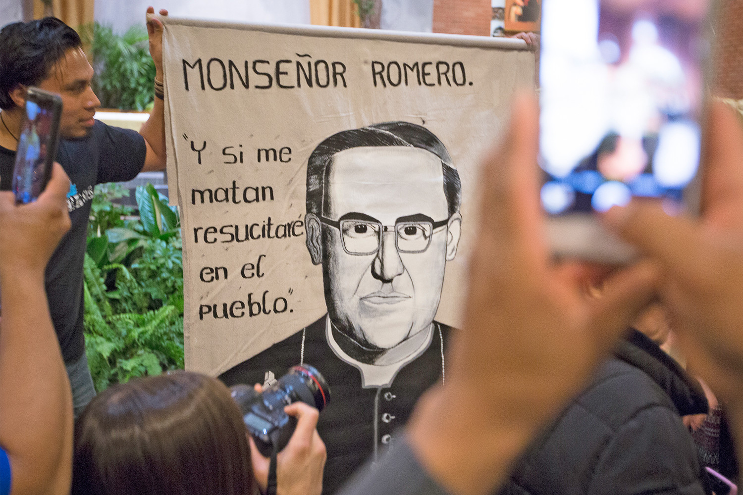 People take sellfies of an image of Blessed Oscar Romero April 10 at St. Camillus Church in Silver Spring, Maryland. During an April 11 homily in Washington, Salvadoran Archbishop Jose Luis Escobar Alas said the canonization of Blessed Romero will “probably” be in Rome and “probably” take place at end of October after a meeting of bishops.